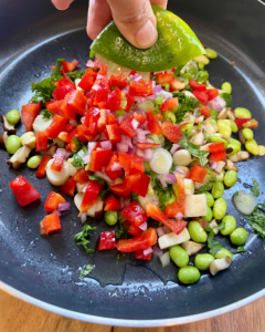 Asian-Inspired Vegan Ceviche, made with heart of palm, shiitake mushrooms, edamame, red peppers, red onion, cilantro, chives, hemp hearts, and a lime Asian-inspired marinade.