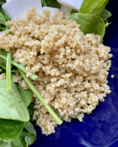 quinoa for vegan Rosemary Almond Salad, made with spinach, arugula, blueberries, pear, vegan feta, quinoa, carrots, toasted almonds and a rosemary dressing.