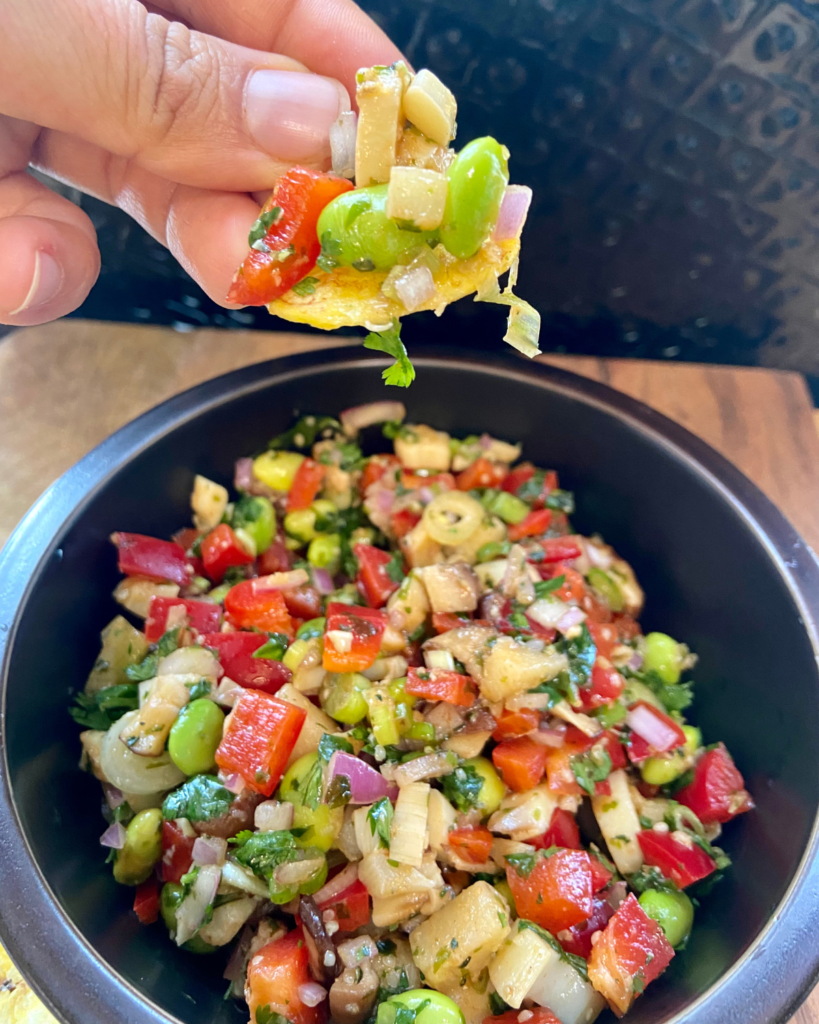 Asian-Inspired Vegan Ceviche, made with heart of palm, shiitake mushrooms, edamame, red peppers, red onion, cilantro, chives, hemp hearts, and a lime Asian-inspired marinade.