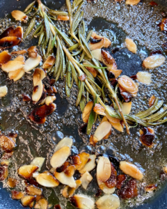 dressing for vegan Rosemary Almond Salad, made with spinach, arugula, blueberries, pear, vegan feta, quinoa, carrots, toasted almonds and a rosemary dressing.