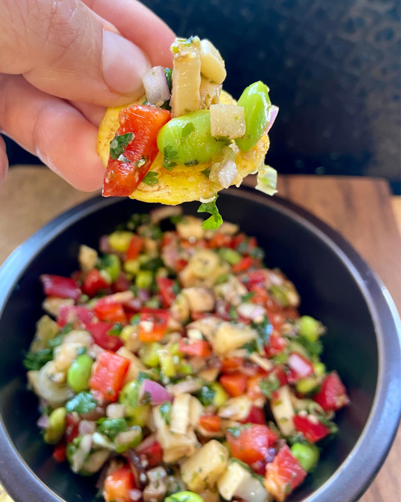 Asian-Inspired Vegan Ceviche, made with heart of palm, shiitake mushrooms, edamame, red peppers, red onion, cilantro, chives, hemp hearts, and a lime Asian-inspired marinade.