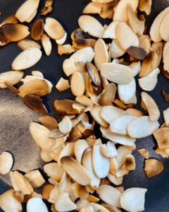 almonds for vegan Rosemary Almond Salad, made with spinach, arugula, blueberries, pear, vegan feta, quinoa, carrots, toasted almonds and a rosemary dressing.