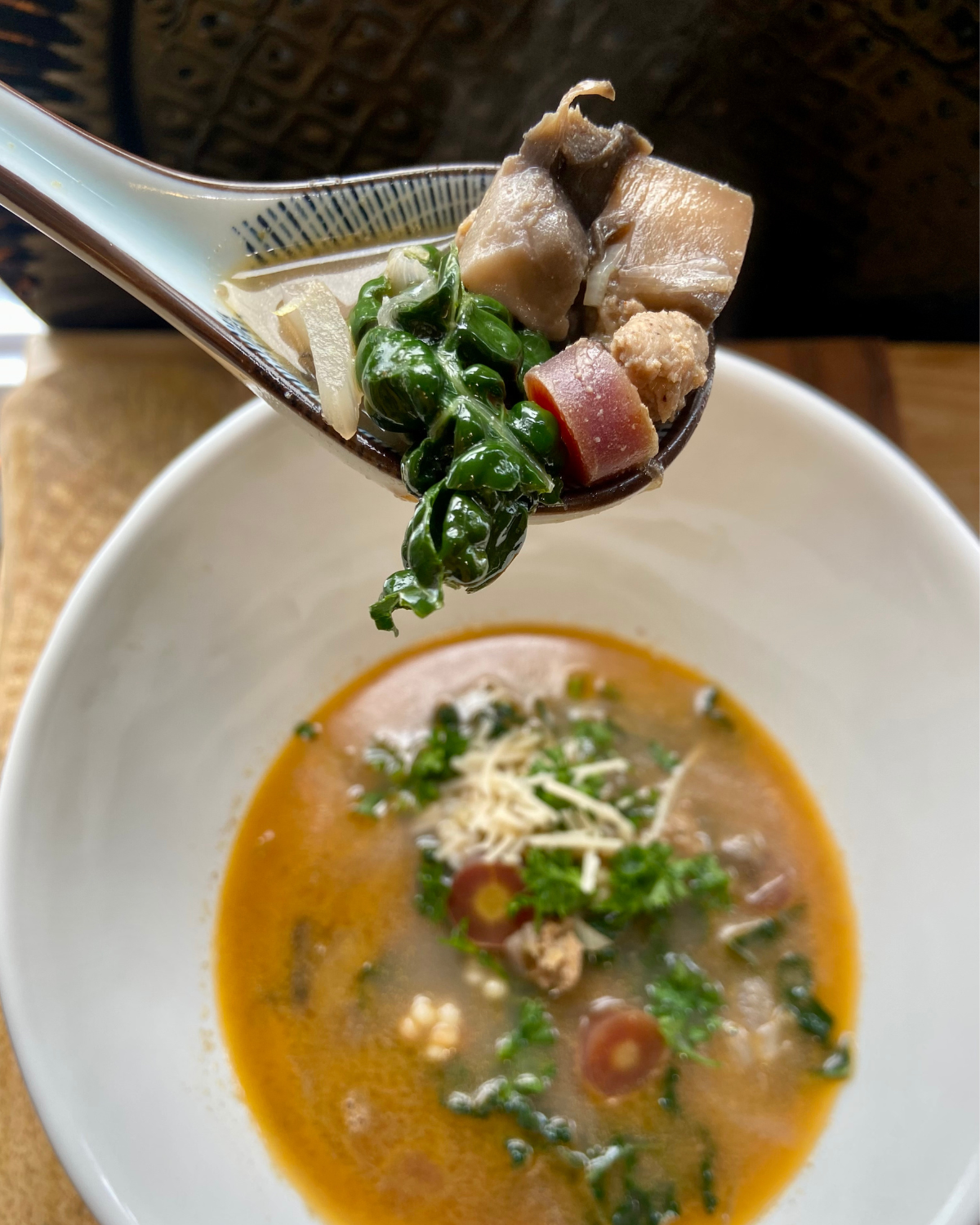 vegan sausage and couscous soup with kale, carrot, fennel