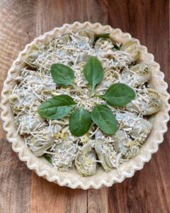 vegan quiche with spinach, artichoke hearts, vegan breakfast sausage, vegan cheese