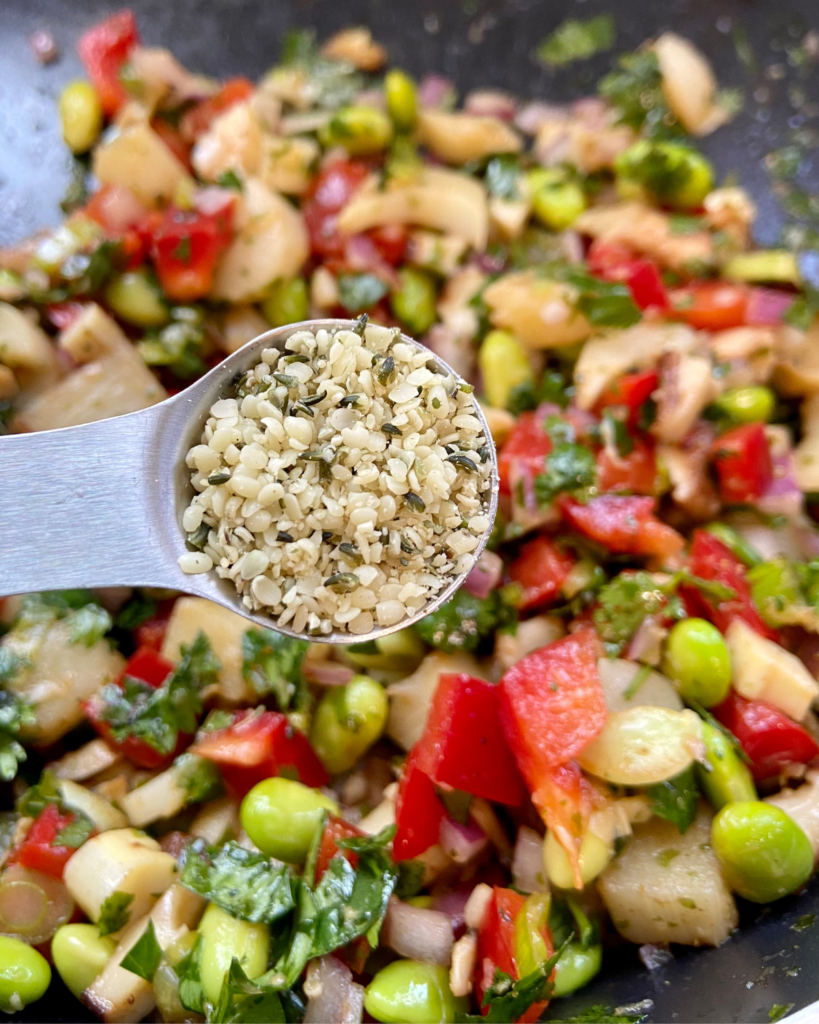 Asian-Inspired Vegan Ceviche, made with heart of palm, shiitake mushrooms, edamame, red peppers, red onion, cilantro, chives, hemp hearts, and a lime Asian-inspired marinade.