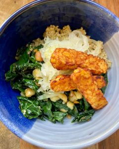 Toasted macadamia nut and kale salad, served with seasoned quinoa, topped with sauerkraut and smoky tempeh. 