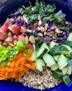 Tofu and almond quinoa salad made with grapes, kale, cabbage, carrots, cucumbers, and a savory Asian dressing. 