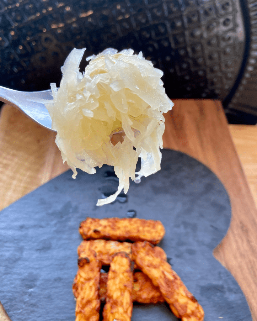 sauerkraut for Toasted macadamia nut and kale salad, served with seasoned quinoa, topped with sauerkraut and smoky tempeh. 