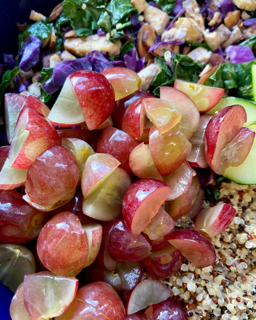 Tofu Almond Quinoa Salad made with grapes, kale, cabbage, carrots, cucumbers, and a savory Asian dressing. 