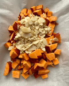 sweet potatoes and almonds for Vegan burrito, loaded with roasted sweet potatoes, toasted almonds, seasoned black beans, quinoa, kale, vegan cheese and topped with cilantro tomato salad, vegan sour cream, and avocado