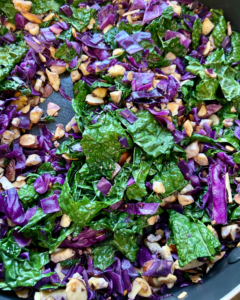 Tofu and almond quinoa salad made with grapes, kale, cabbage, carrots, cucumbers, and a savory Asian dressing. 