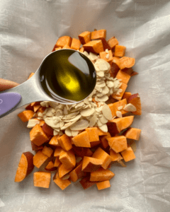 sweet potatoes and almonds for Vegan burrito, loaded with roasted sweet potatoes, toasted almonds, seasoned black beans, quinoa, kale, vegan cheese and topped with cilantro tomato salad, vegan sour cream, and avocado