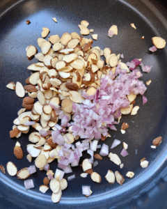 shallots and almonds for Tofu and almond quinoa salad made with grapes, kale, cabbage, carrots, cucumbers, and a savory Asian dressing. 