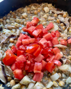 adding tomatoes to skillet