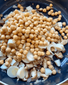 adding heart of palm and chickpeas to skillet