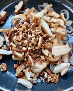 adding mushrooms and pecans to pan