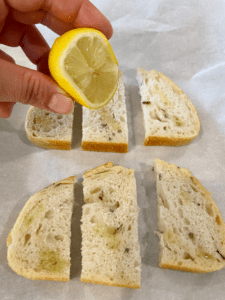 squeezing lemon on rosemary sourdough bread