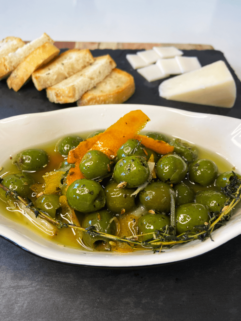 warm marinated olives and rosemary sourdough bread for charcuterie board