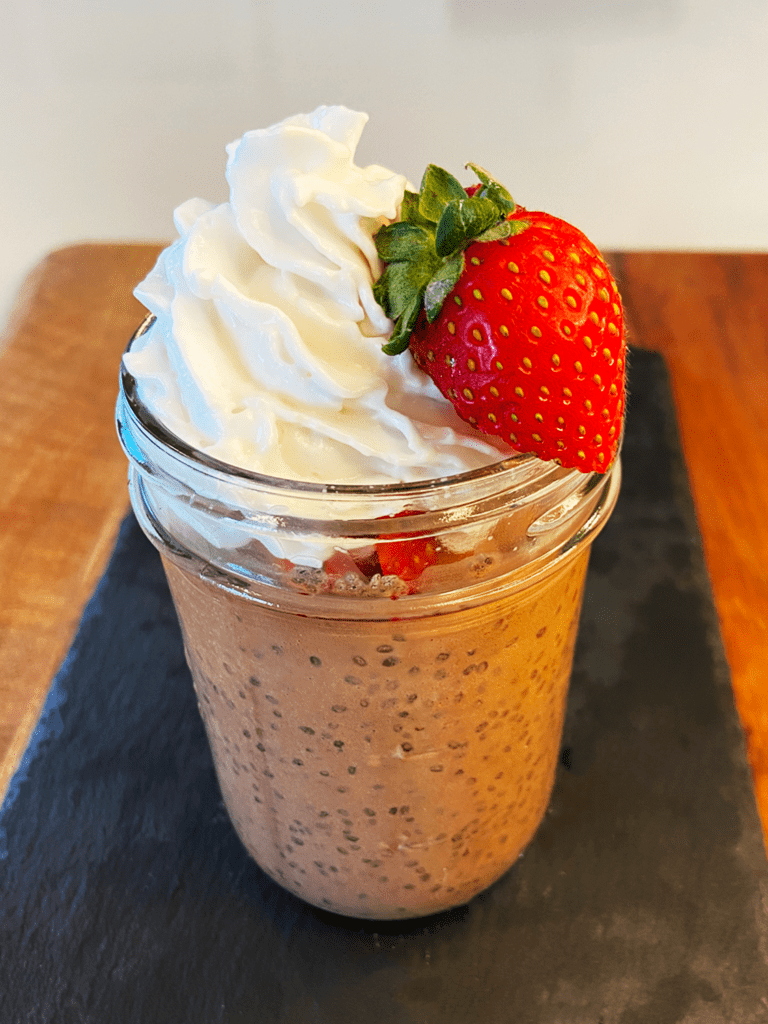 black licorice chia seed pudding recipe made with oat milk, topped with whipped cream