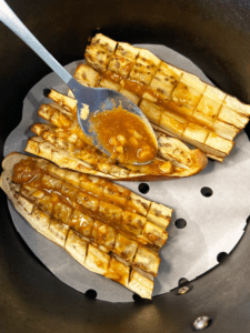 putting miso sake sauce on air fried eggplant