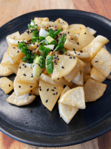 roasted daikon radishes topped with sesame seeds and scallions