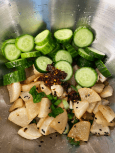 ingredients for spicy roasted daikon radish and cucumber salad in a bowl