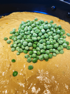 adding peas to vegan cheese sauce