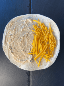 vegan cheese and vegan cream cheese spread on tortilla