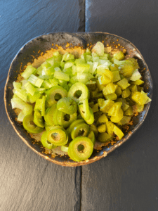 pickles, olives, and celery chopped up on a dish