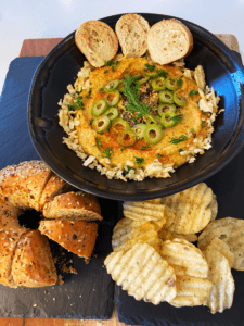 vegan deviled egg dip served with chips and sliced bagel