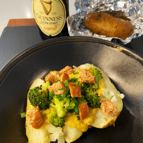 vegan Irish loaded baked potatoes with bangers, broccoli and Guinness cheese sauce