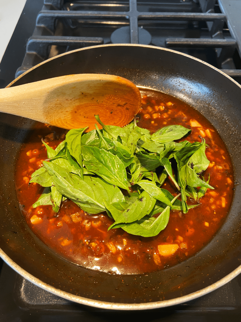 adding Thai basil to sauce