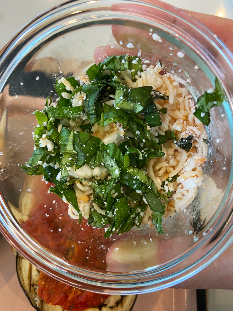 vegan cheese and basil mixed for Vegan Garlic Butter Stuffed Eggplant Parmesan