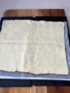 laying out pizza dough