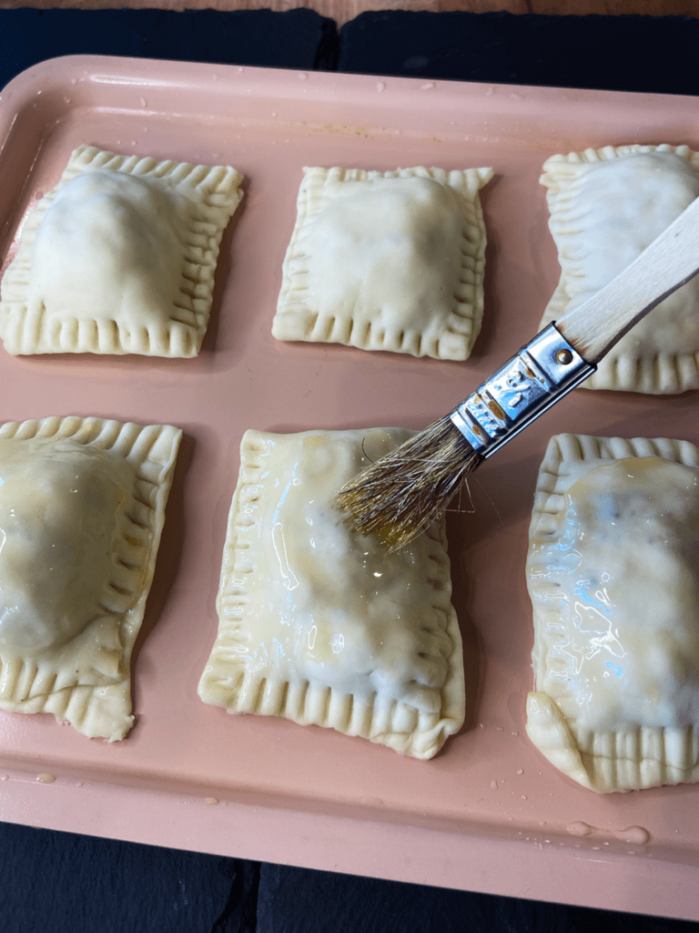 brushing oil on  air fryer vegan hot pockets 