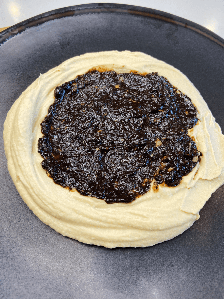 hummus and black garlic dip spread on plate