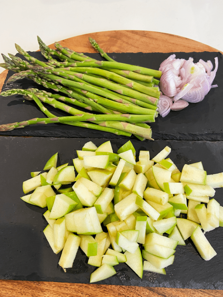 apples, shallots, and asparagus cut on board