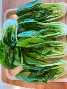 oiled and seasoned bok choy on an air fryer tray